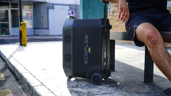 Homme assis à côté de la Station électrique portable 3600Wh – EcoFlow DELTA Pro sur un trottoir.